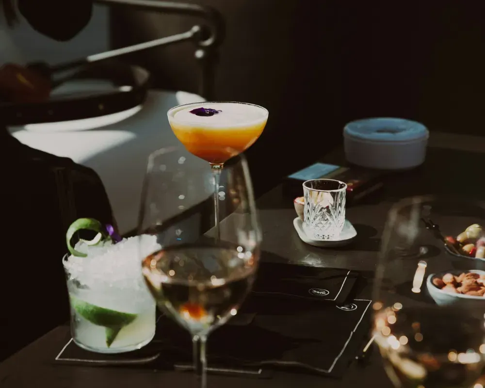 An evening cocktail spread with crystal glassware and a passion fruit martini